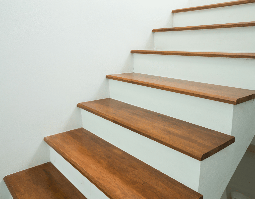 Staircase with newly refinished wood treads and smooth pale green painted risers