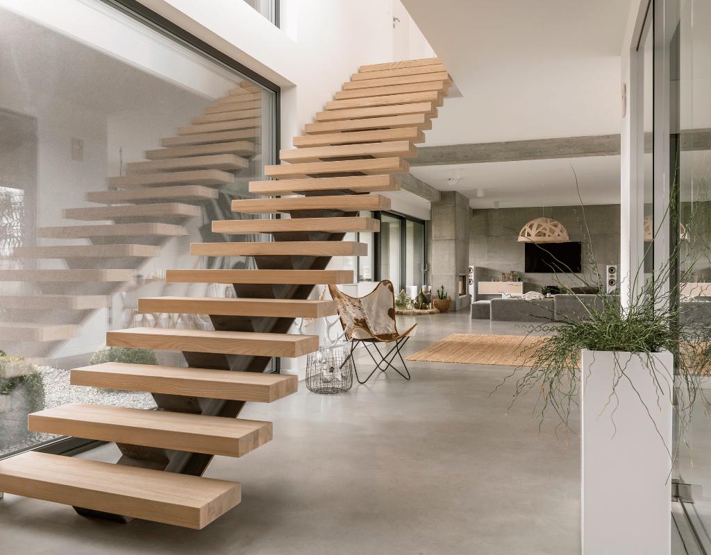 Floating staircase with open light wood treads rising through a bright open-plan living space